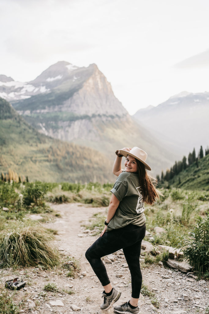 Girl stands in front of massive mountain landscape