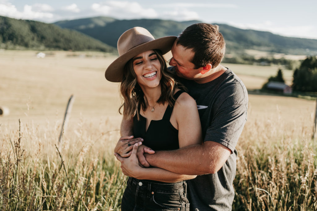 couple hugging each other in a field in Bozeman, Montana.
