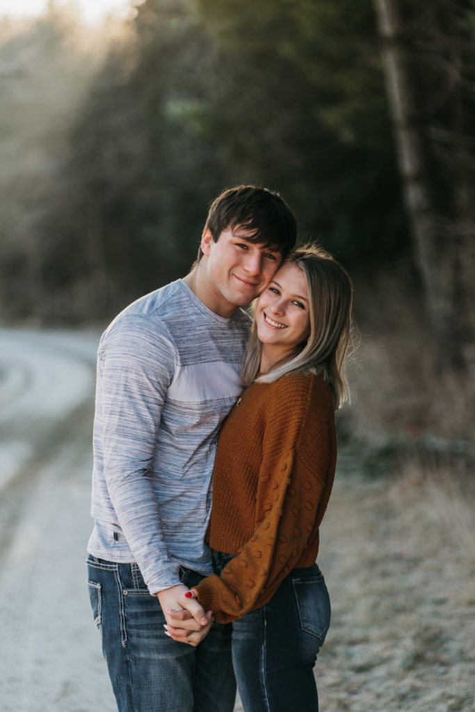 A couple smiles and looks at the camera during an engagement session in Minnesota