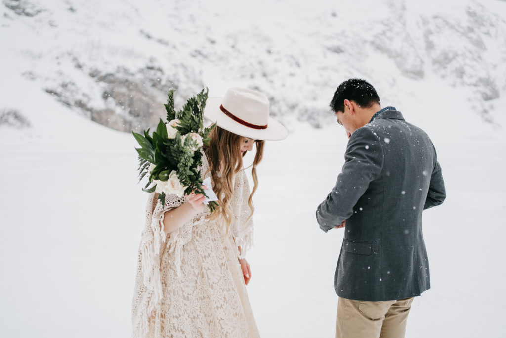 Eloping couple stands in the snow in the Rocky Mountains