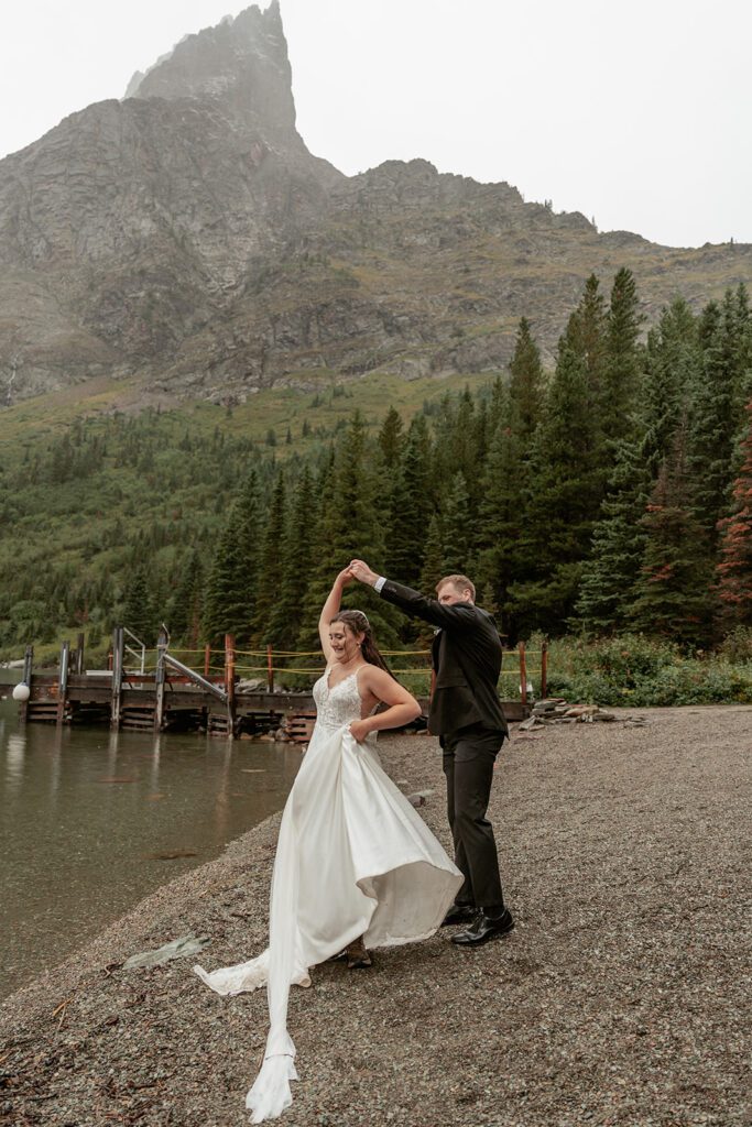 Newlyweds share a first dance along the shores of Lake Josephine in Glacier National Park.
