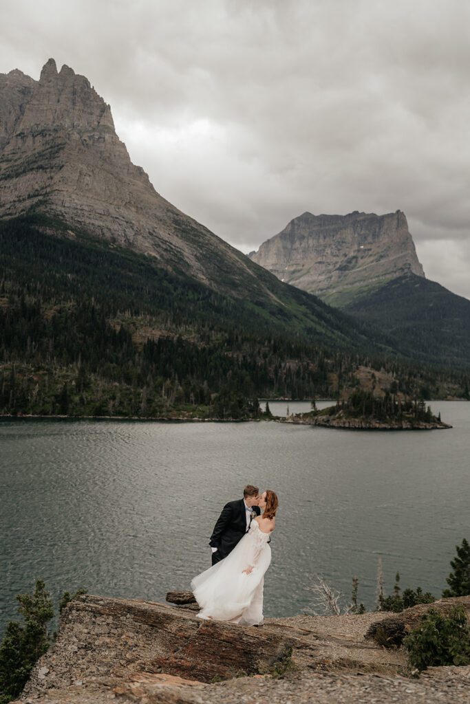 Elopement couple share a kiss at Sun Point in Glacier National Park