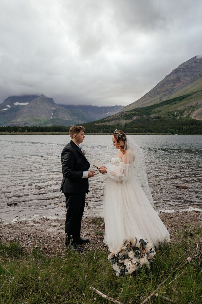 Bride and groom share private vows at Many Glacier Southwest Beach in Glacier National Park.