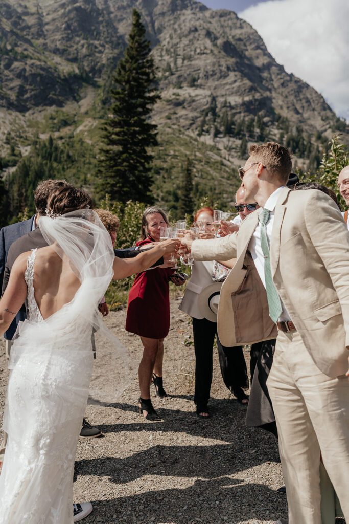 Newlyweds toast champagne at Pray Lake in Glacier National Park following their intimate wedding ceremony on the shore.