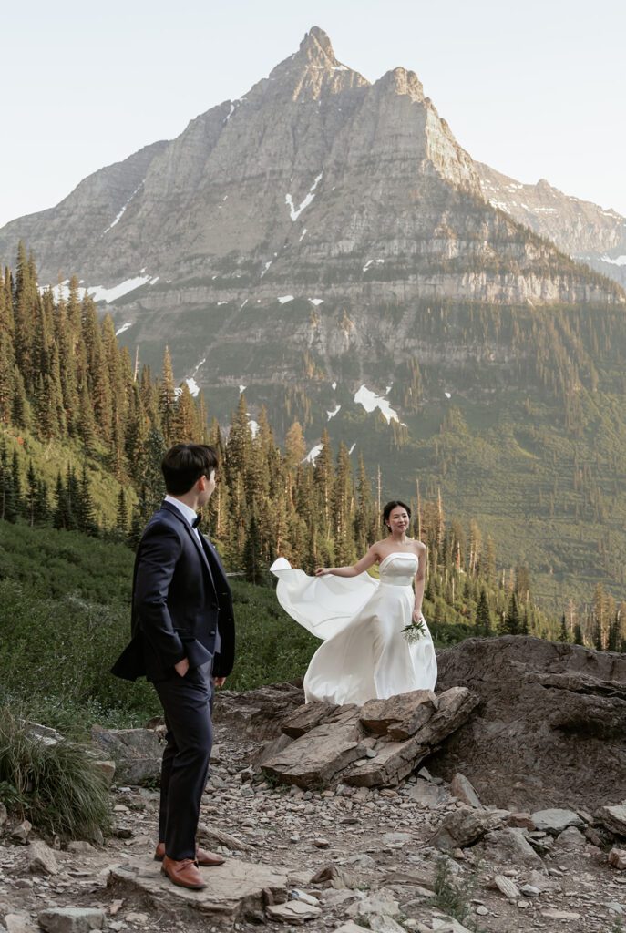 A classic bride and groom take in the views of Big Bend in Glacier National Park during a whimsical evening adventure session