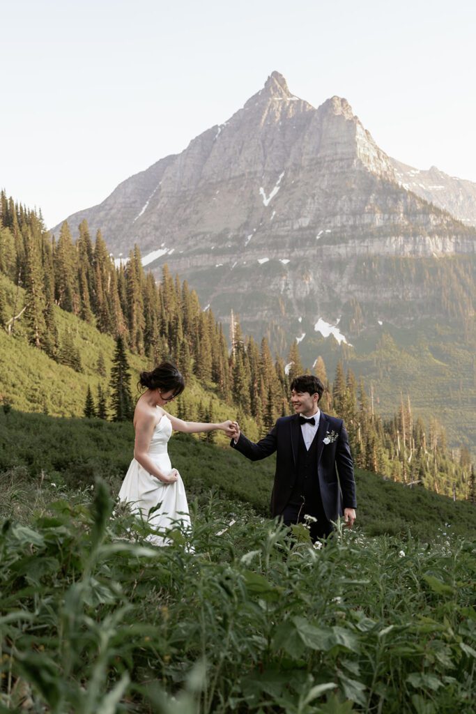 A classic bride and groom take in the views of Big Bend in Glacier National Park during a whimsical evening adventure session