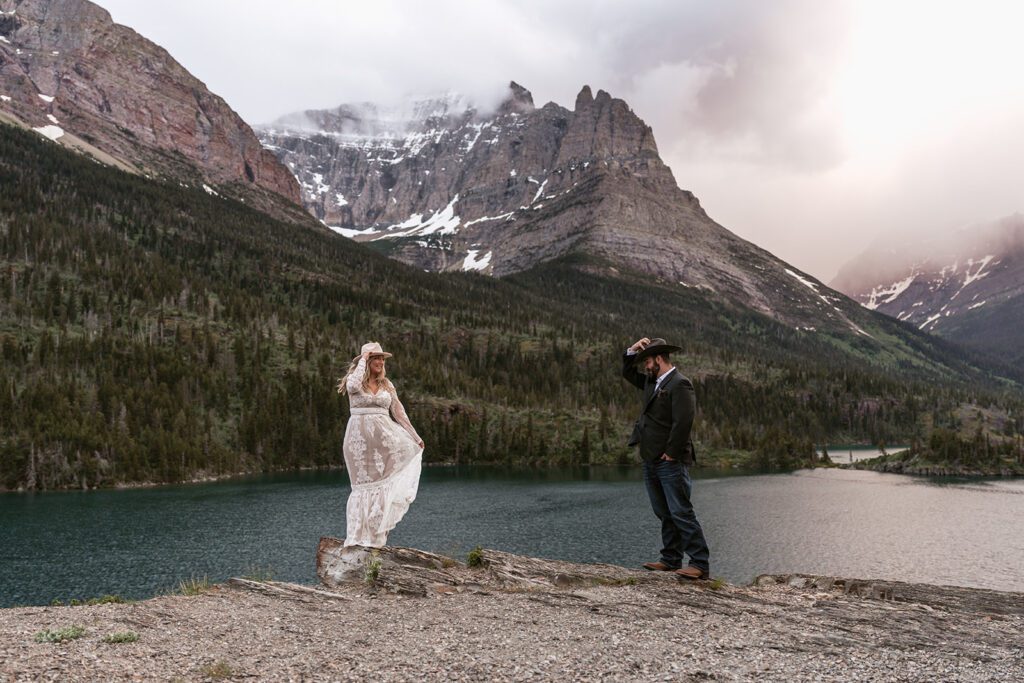 A boho bride and groom frolic at Sun Point beneath a beautiful, moody sunset in Glacier National Park.