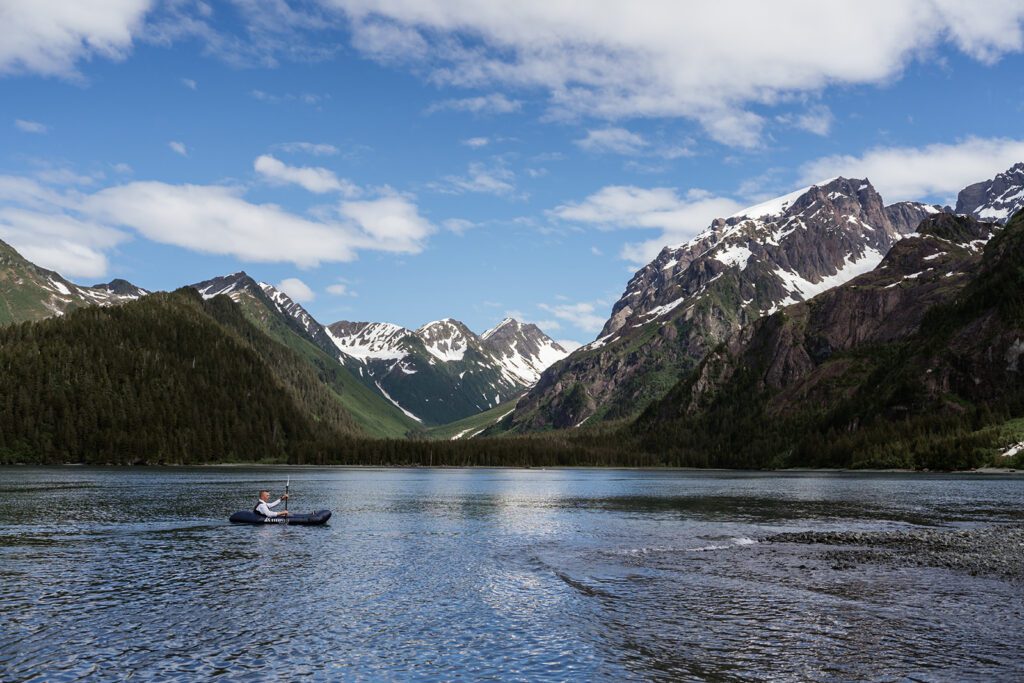 A groom floats on a pack-raft in Resurrection Bay during an intimate vow renewal in Seward